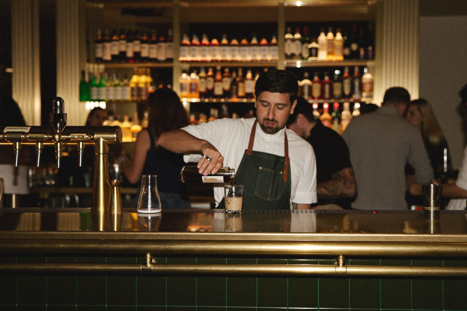 Bartender pouring wine behind a modern bar