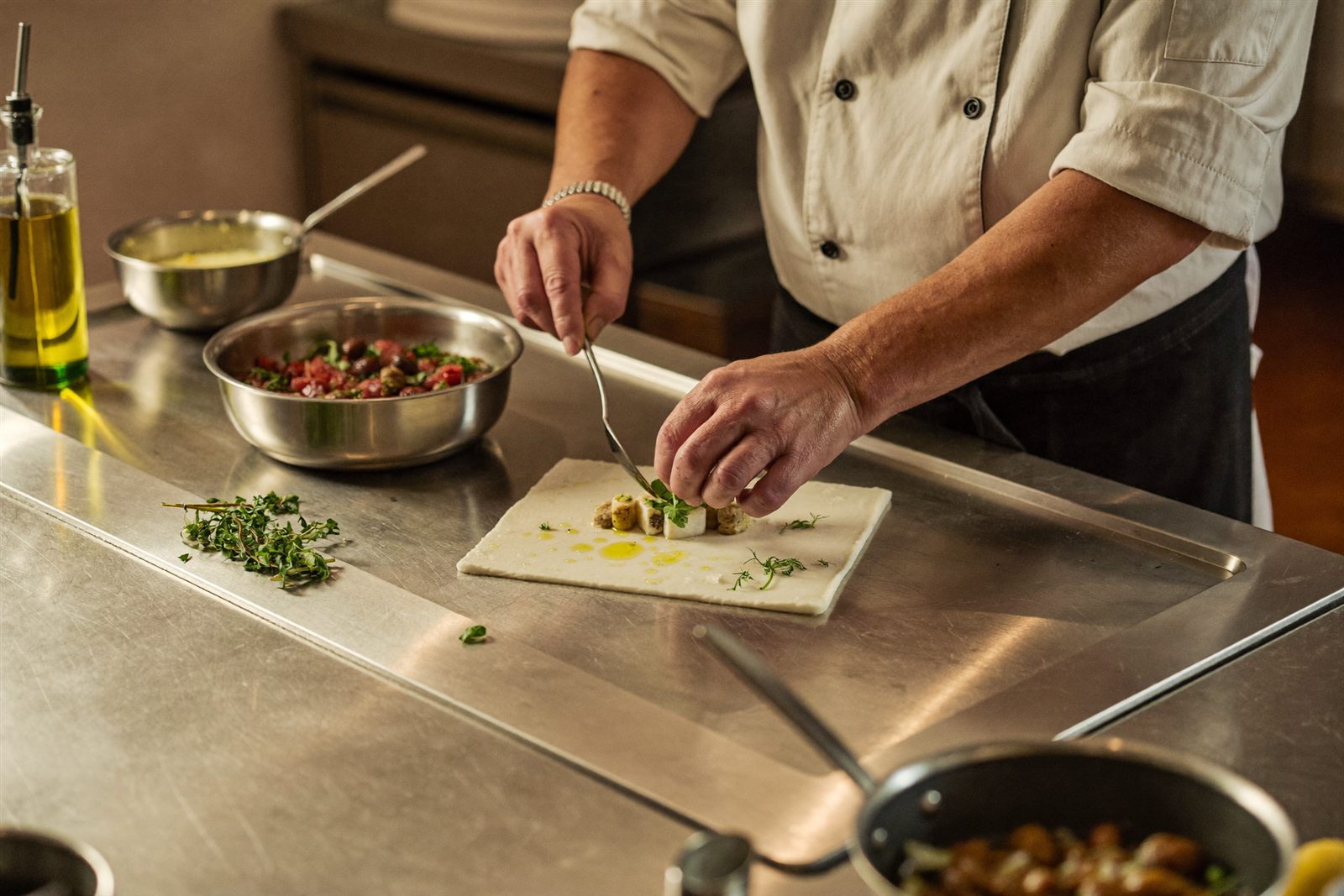 Head chef plating a dish at the pass